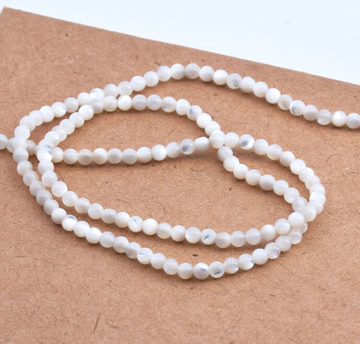 Kaufen Sie Perlen in Deutschland Weiße runde Muschelperlen 2 mm - Loch: 0.5 mm (1 Strang - 39 cm)